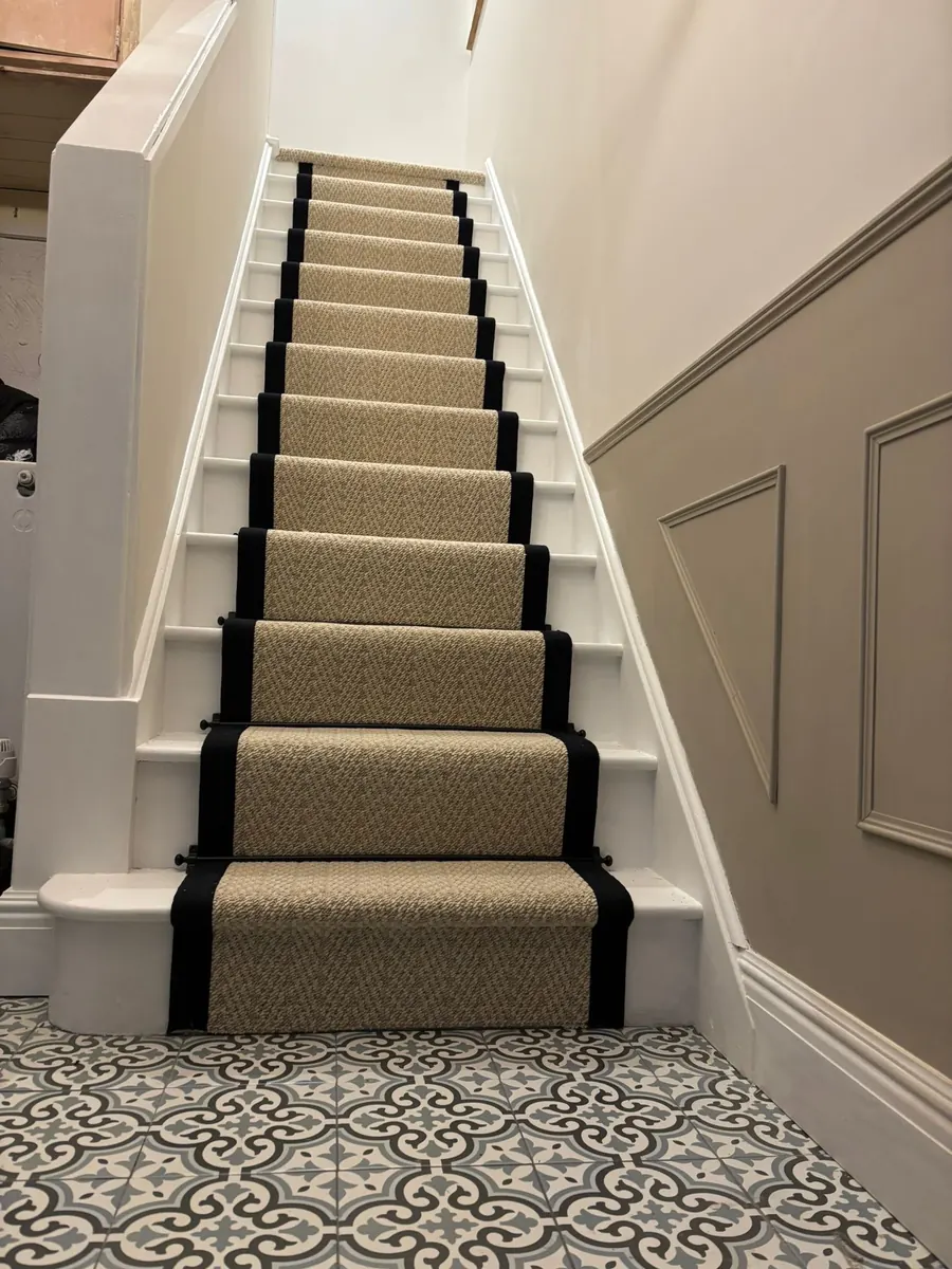 A carpet stair runner fitted with a dark border