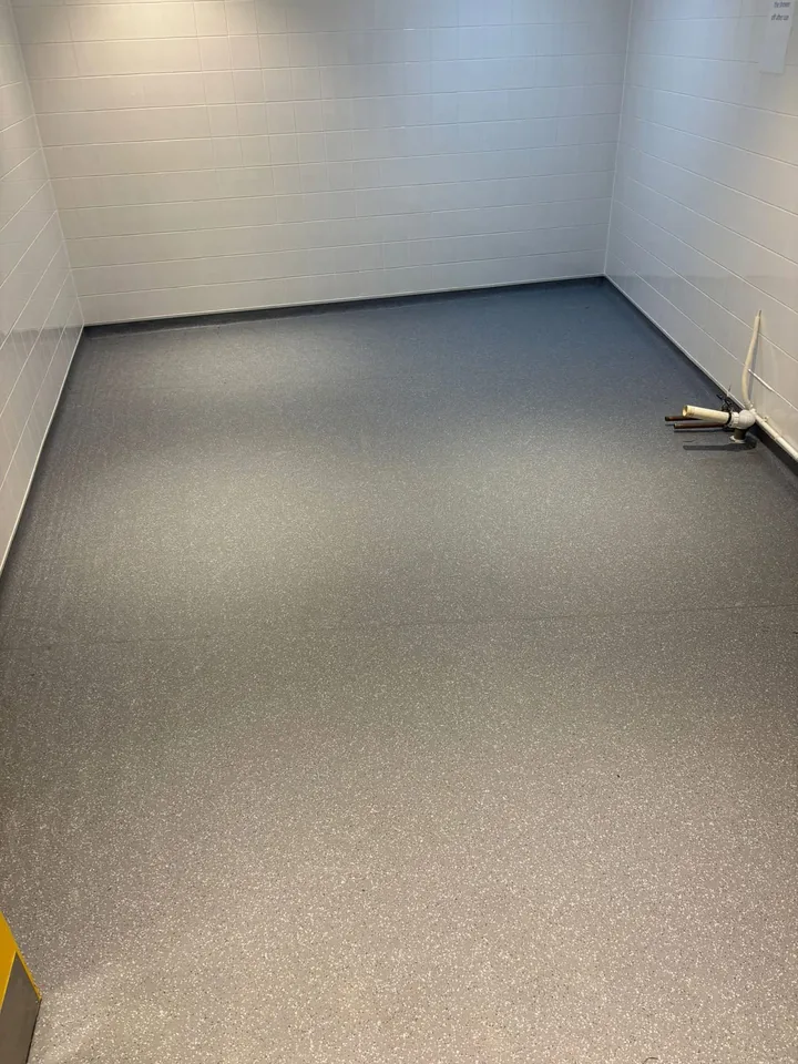 A finished washroom floor with edges fitted up to the walls